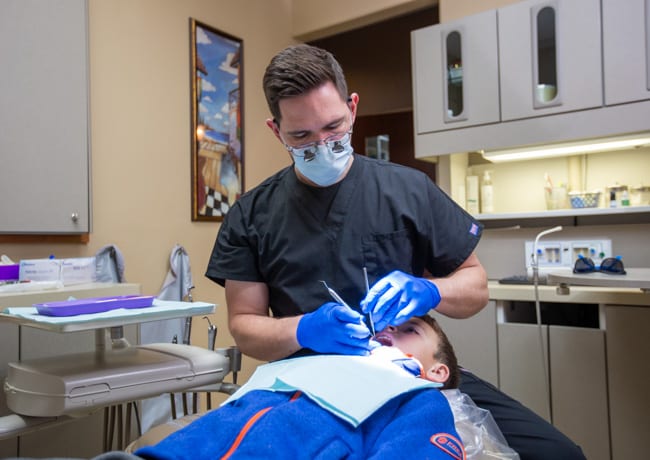 Dr. Kufahl is also a pediatric dentist and performs dental work on a child in this photo.