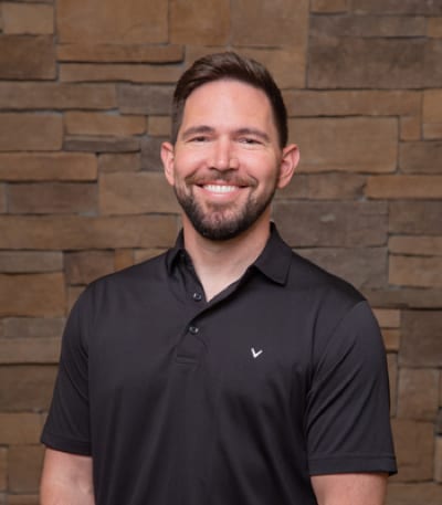 Dr. Kufahl poses for his headshot with a youthful energy and smiles from ear to ear with a pearly white grin.
